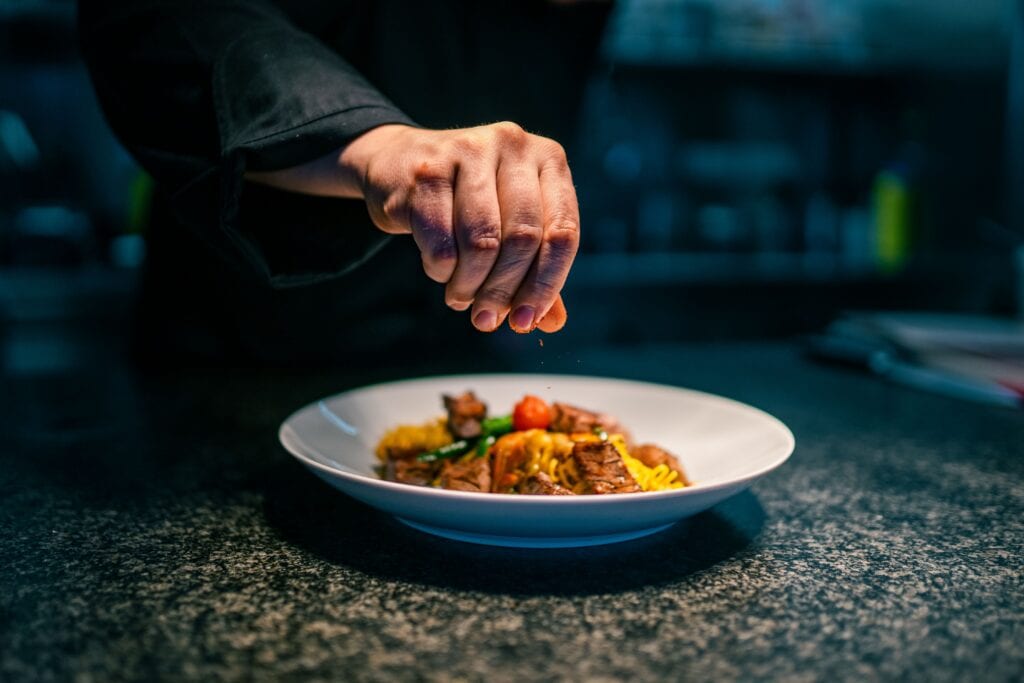 A closeup shot of a chef's hand while preparing the food